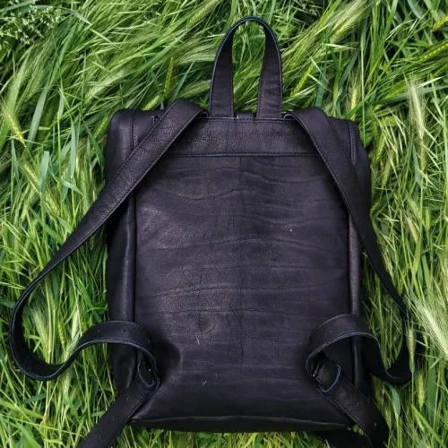 Rucsac laptop din piele nabuc negru KC Wabi-Sabi, așezat pe iarbă, vedere din spate