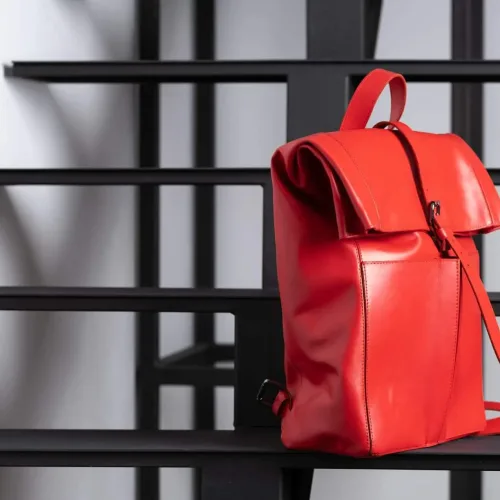 Rucsac laptop din piele naturală roșie Wabi-Sabi, așezat pe trepte, vedere laterală
