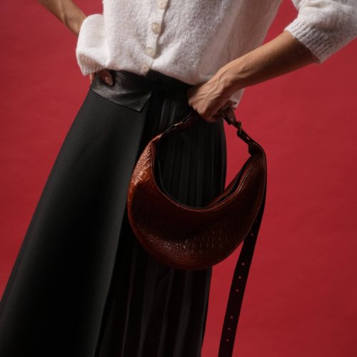 Geantă Nuna Mini din piele naturală maro cognac, ținută în mână, vedere laterală