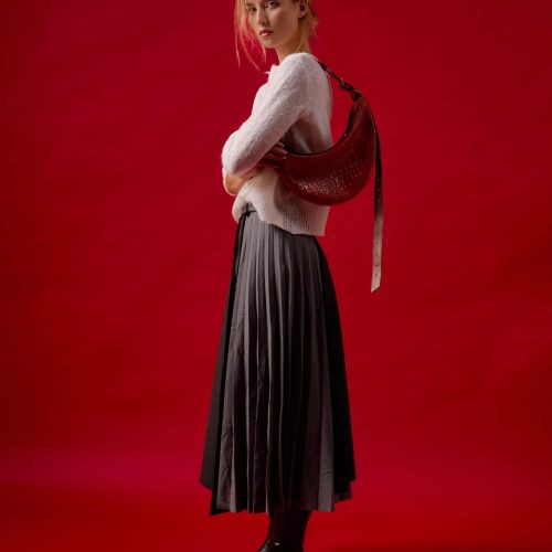 Geantă Nuna Mini din piele naturală maro cognac, purtată pe umăr