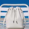 Geantă bucket Juliette Midi din piele naturală albă, vedere frontală, așezată pe un scaun alb